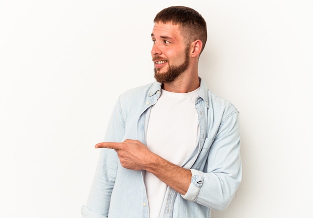 Il giovane uomo caucasico con diastema isolato su sfondo bianco guarda da parte sorridente, allegro e piacevole.