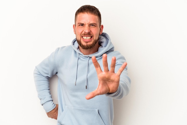 Young caucasian man with diastema isolated on white background showing claws imitating a cat, aggressive gesture