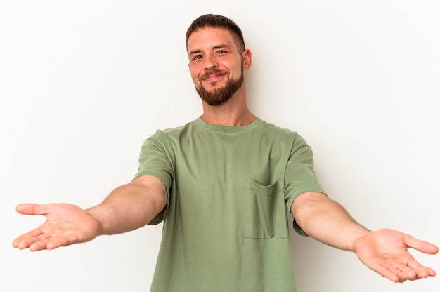 Foto giovane uomo caucasico con diastema isolato su sfondo bianco che mostra un'espressione di benvenuto.