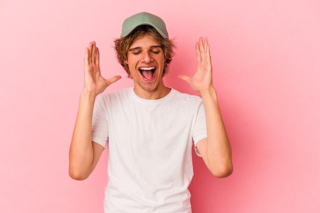 Young caucasian man with make up isolated on pink background joyful laughing a lot. Happiness concept.