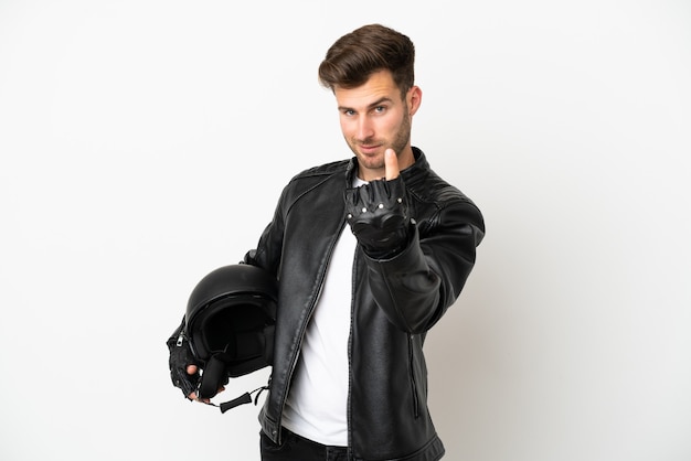 Young caucasian man with a motorcycle helmet isolated on white background doing coming gesture