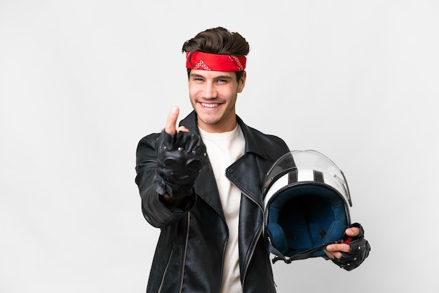 Young caucasian man with a motorcycle helmet over isolated white background doing coming gesture