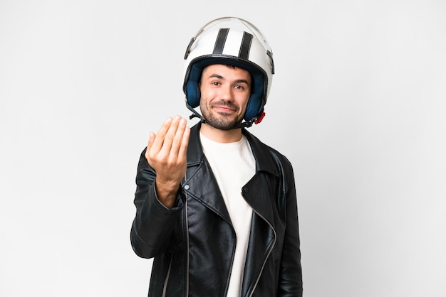 Молодой кавказский мужчина в мотоциклетном шлеме на изолированном белом фоне приглашает прийти с рукой Рад, что ты пришел