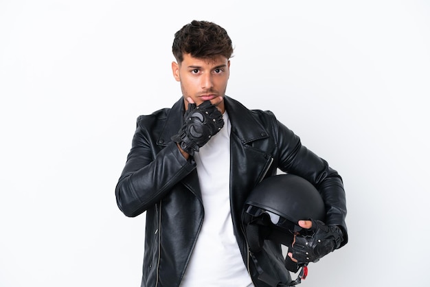 Young caucasian man with a motorcycle helmet isolated on white background thinking