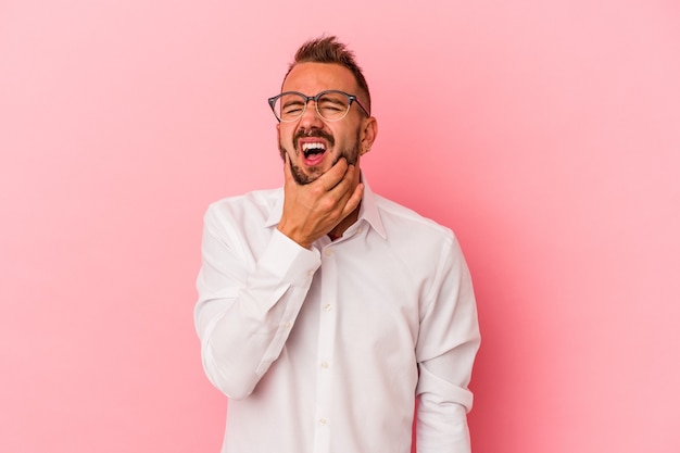 Young caucasian man with tattoos isolated on pink background  having a strong teeth pain, molar ache.