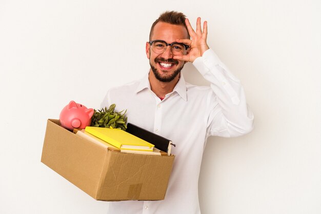 Young caucasian man with tattoos moving home isolated on white background  excited keeping ok gesture on eye.