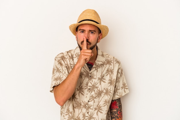 Young caucasian man with tattoos wearing summer clothes isolated on white background  keeping a secret or asking for silence.