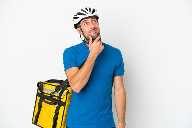 Young caucasian man with thermal backpack isolated on white background looking up while smiling