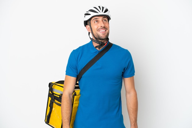 Young caucasian man with thermal backpack isolated on white background thinking an idea while looking up