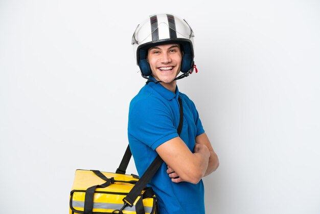 Young caucasian man with thermal backpack isolated on white background with arms crossed and looking forward