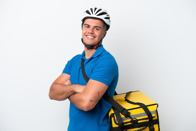 Young caucasian man with thermal backpack isolated on white background with arms crossed and looking forward