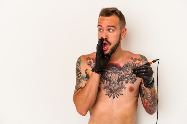 Foto il giovane uomo caucasico senza t-shirt isolato su sfondo bianco sta dicendo una notizia segreta di frenata calda e sta guardando da parte