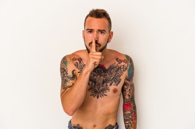Young caucasian man without t-shirt isolated on white background  keeping a secret or asking for silence.