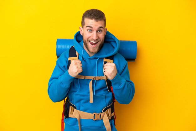 Young caucasian mountaineer man with a big backpack isolated