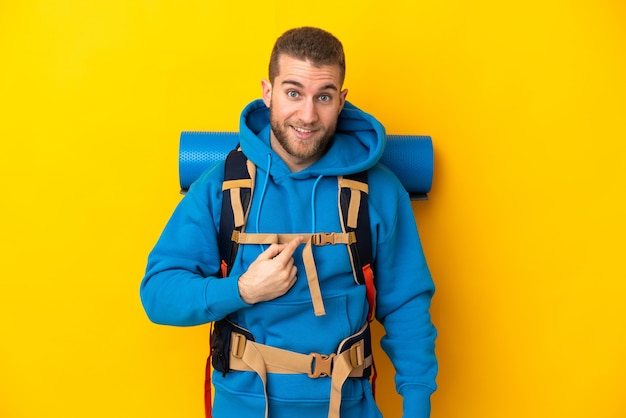 Young caucasian mountaineer man with a big backpack isolated