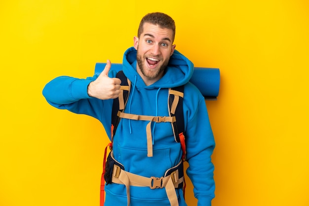 Young caucasian mountaineer man with a big backpack isolated