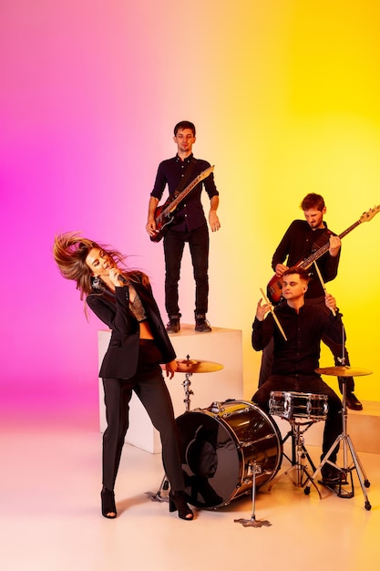 Giovani musicisti caucasici, band che si esibisce in luce al neon su sfondo sfumato per studio