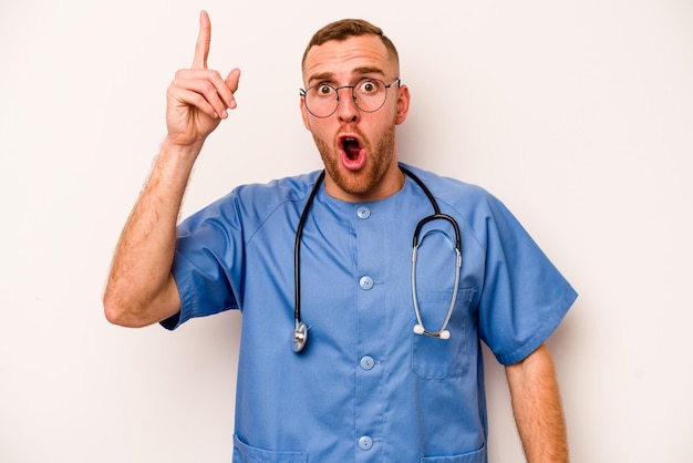 Young caucasian nurse man isolated on white background having an idea inspiration concept