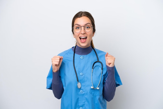 Young caucasian nurse woman isolated on white background celebrating a victory in winner position