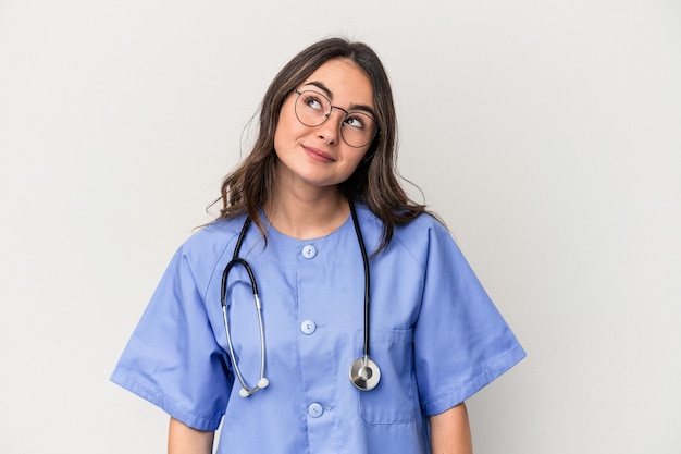 Young caucasian nurse woman isolated on white background dreaming of achieving goals and purposes