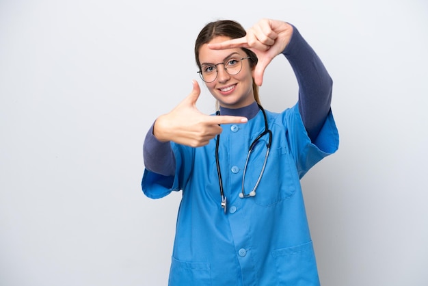 Young caucasian nurse woman isolated on white background focusing face Framing symbol