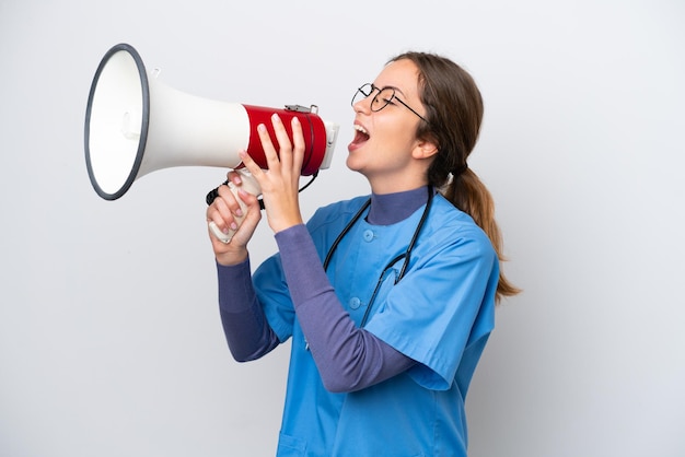 Young caucasian nurse woman isolated on white background shouting through a megaphone