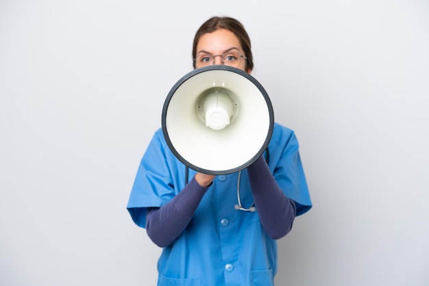 Young caucasian nurse woman isolated on white background shouting through a megaphone