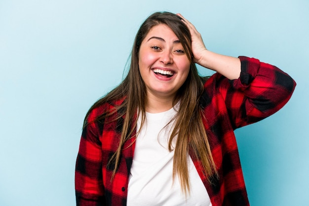 Young caucasian overweight woman isolated on blue background being shocked, she has remembered important meeting.