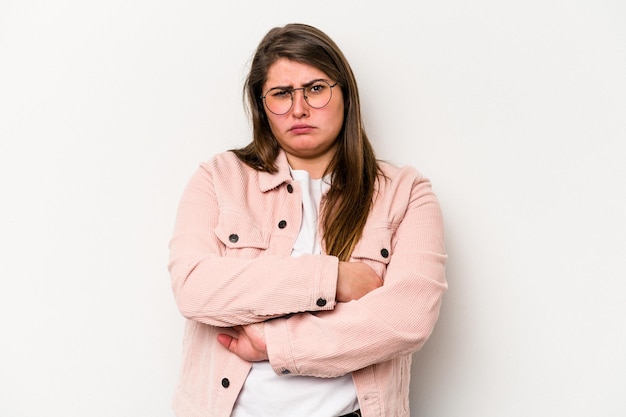 Young caucasian overweight woman isolated on white background frowning face in displeasure keeps arms folded