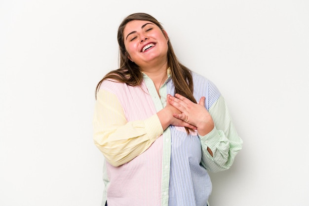 Young caucasian overweight woman isolated on white background has friendly expression, pressing palm to chest. Love concept.