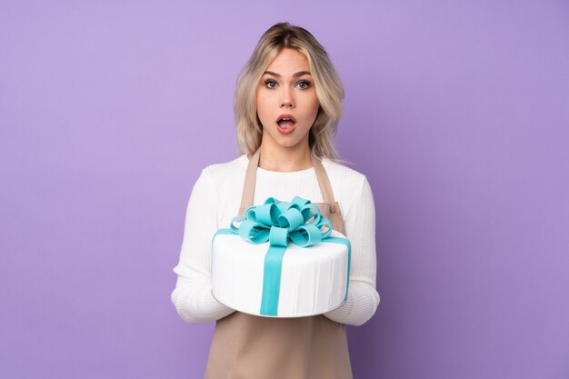 Young caucasian pastry woman over purple wall