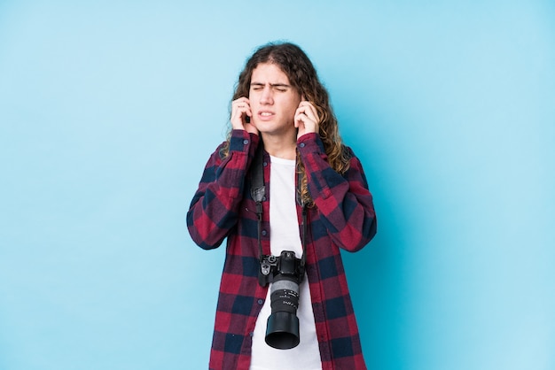 Young caucasian photographer man isolated covering ears with hands.