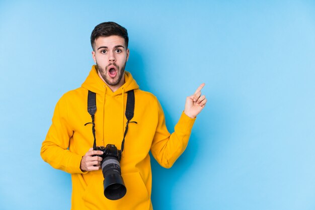 Young caucasian photographer man isolated pointing to the side