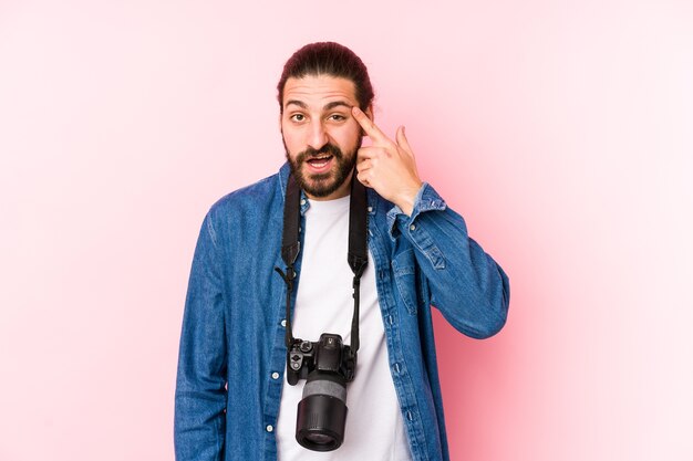 Young caucasian photographer man isolated showing a disappointment gesture with forefinger.