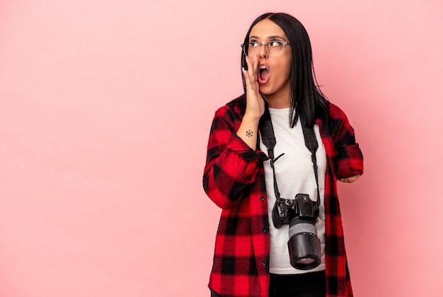 Young caucasian photography woman with one arm isolated on pink background raising fist after a victory, winner concept.