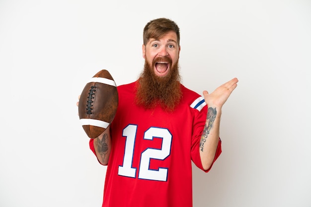 Young caucasian reddish man playing rugby isolated on white background with shocked facial expression