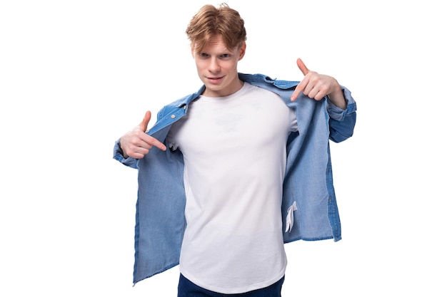 young caucasian redhaired man in a denim shirt over a white tshirt posing fashionably