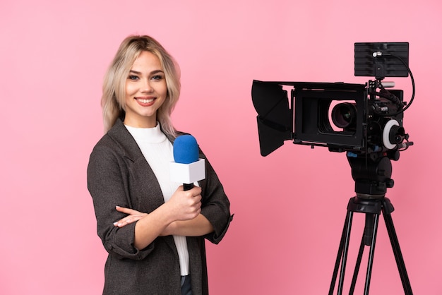 Young caucasian reporter woman over isolated pink wall