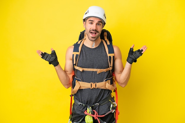 Young caucasian rock climber man isolated on yellow background with shocked facial expression