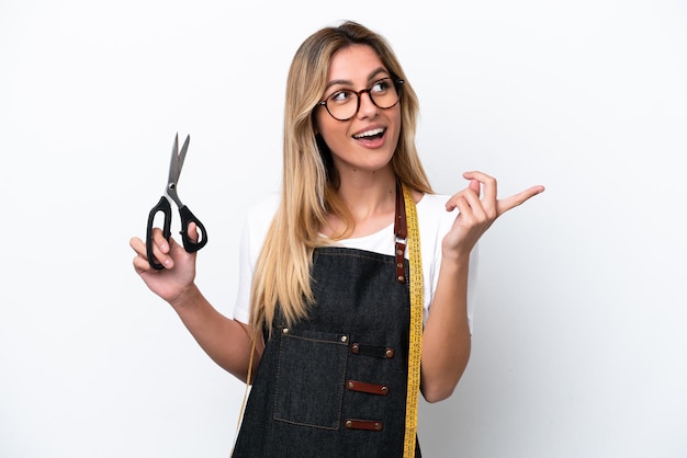 Young caucasian seamstress woman isolated on white background intending to realizes the solution while lifting a finger up