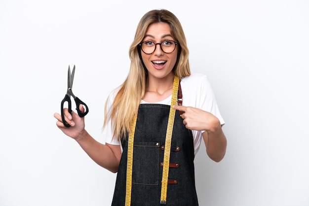 Young caucasian seamstress woman isolated on white background with surprise facial expression