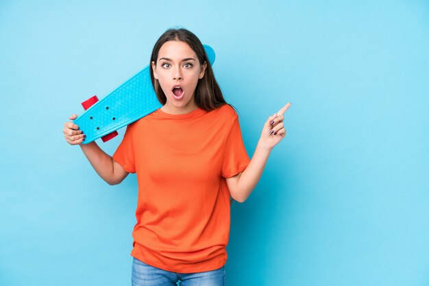 Young caucasian skater woman isolated pointing to the side