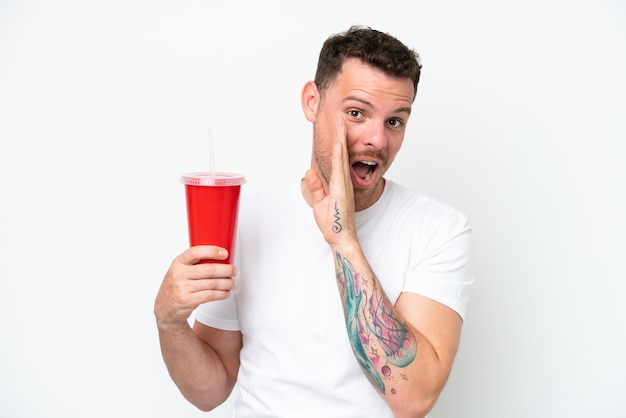 Young caucasian soda holding soda isolated on white background whispering something