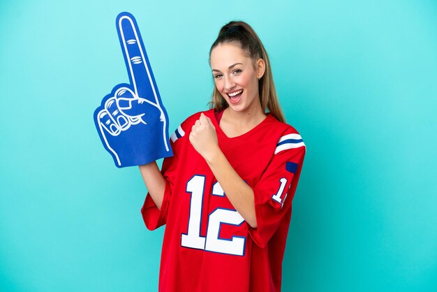 Young caucasian sport woman isolated on blue background celebrating a victory