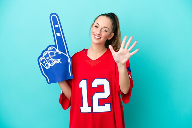 Young caucasian sport woman isolated on blue background counting five with fingers