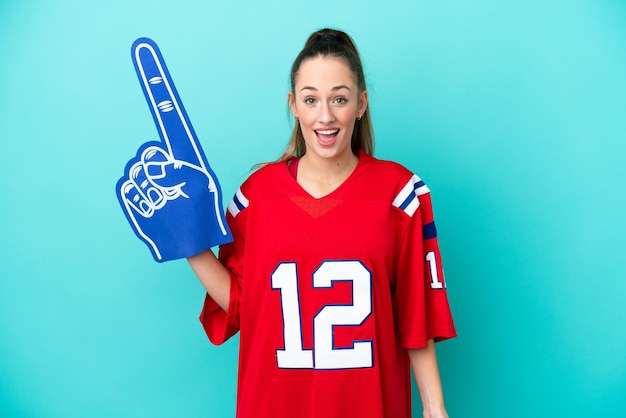 Young caucasian sport woman isolated on blue background with surprise facial expression