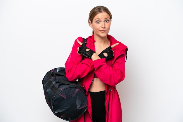 Young caucasian sport woman isolated on white background pointing to the laterals having doubts