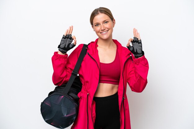 Young caucasian sport woman isolated on white background showing an ok sign with fingers