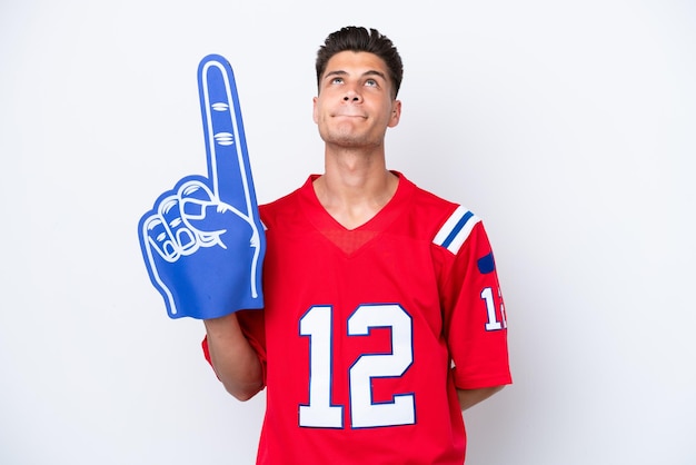 Young caucasian sports fan man isolated on white background and looking up