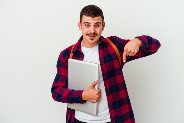 Young caucasian student man holding a laptop isolated on white wall points down with fingers, positive feeling.